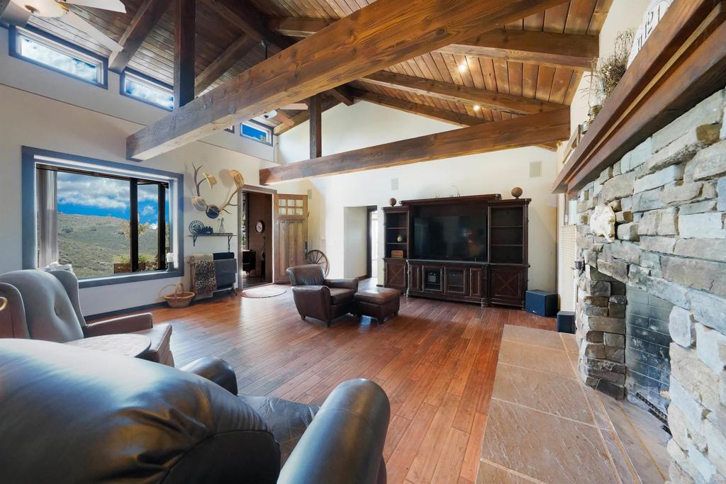 21057 Sutherland Dam Road Ramona, CA 92065 - Photo 22 of 66 a living room with furniture a flat screen tv and a fireplace