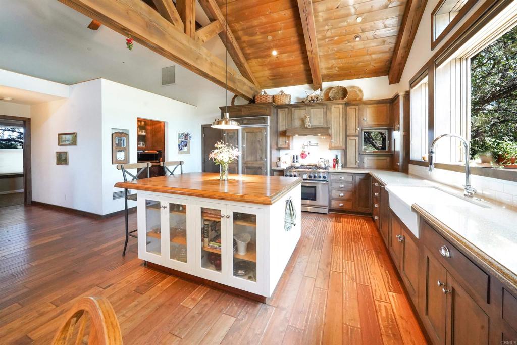 21057 Sutherland Dam Road Ramona, CA 92065 - Photo 26 of 66 a large white kitchen with wooden floors and center
