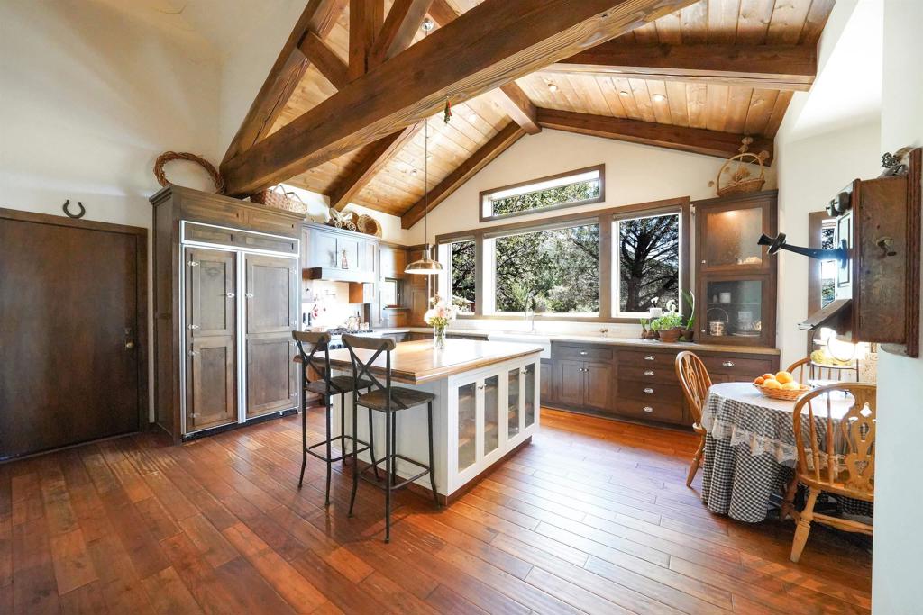 21057 Sutherland Dam Road Ramona, CA 92065 - Photo 28 of 66 a kitchen with stainless steel appliances granite countertop a table chairs and a wooden floor