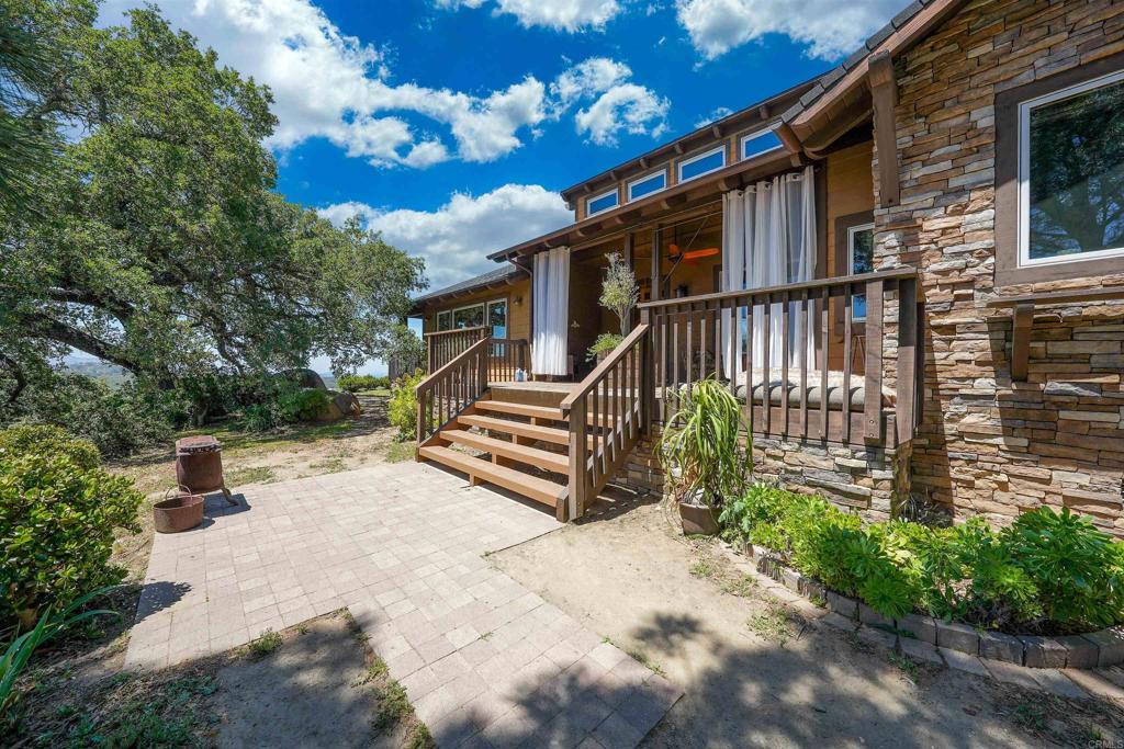 21057 Sutherland Dam Road Ramona, CA 92065 - Photo 4 of 66 a view of a chair and table in the back yard of the house