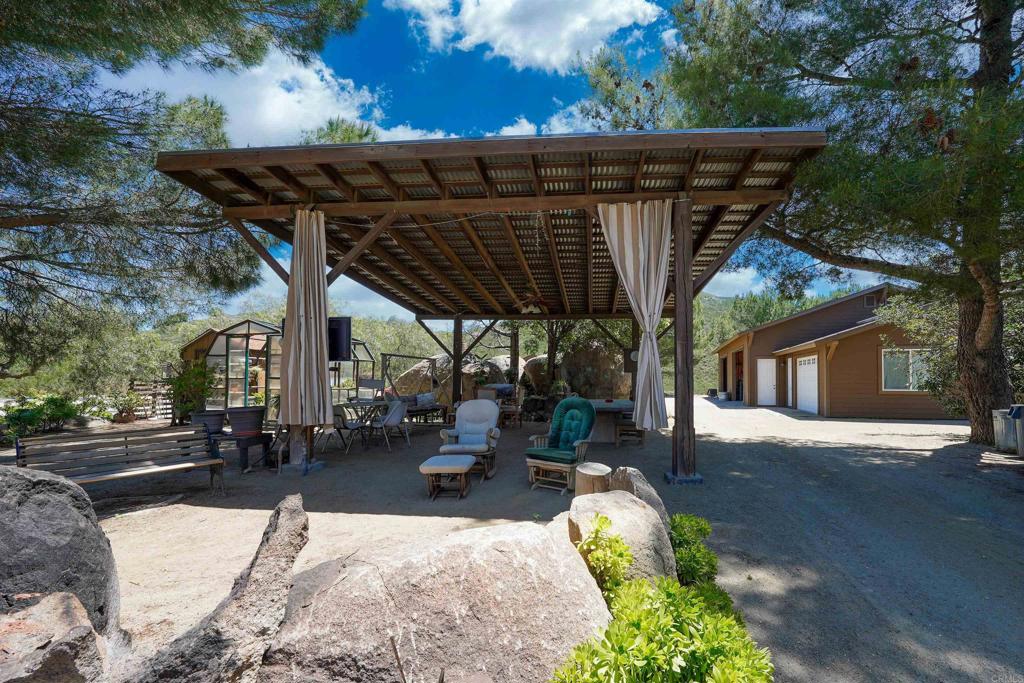 21057 Sutherland Dam Road Ramona, CA 92065 - Photo 55 of 66 a view of a patio with table and chairs with wooden fence