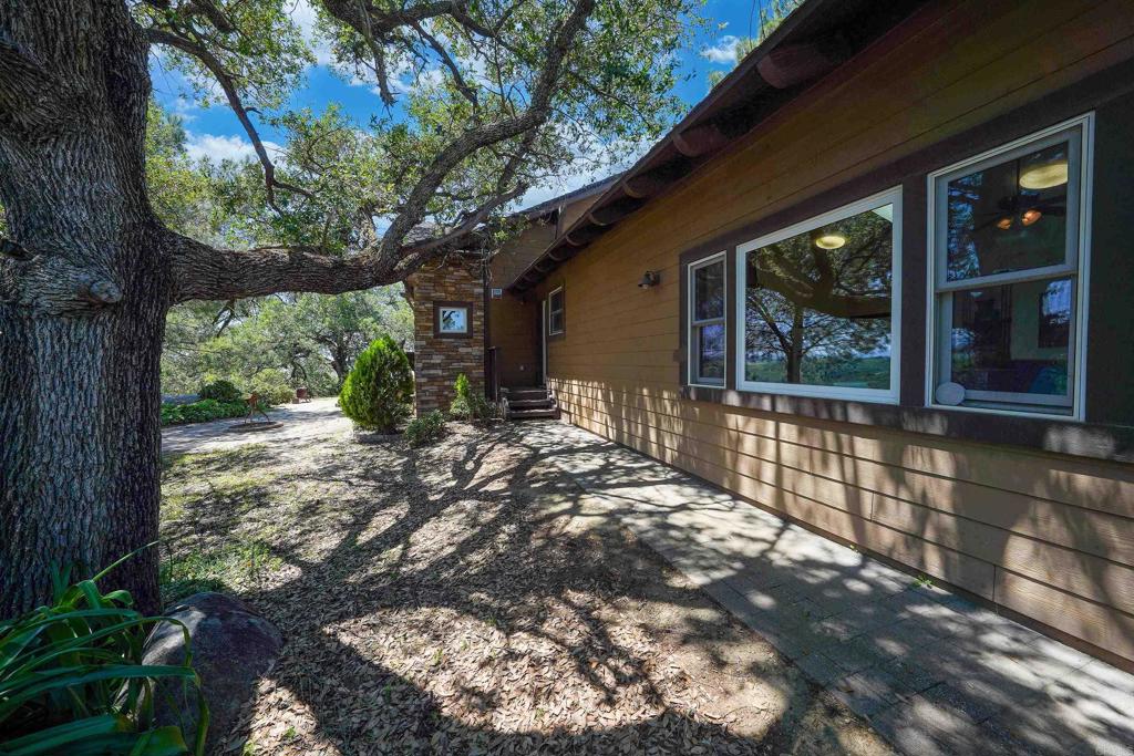 21057 Sutherland Dam Road Ramona, CA 92065 - Photo 7 of 66 a view of a house with a tree in the yard