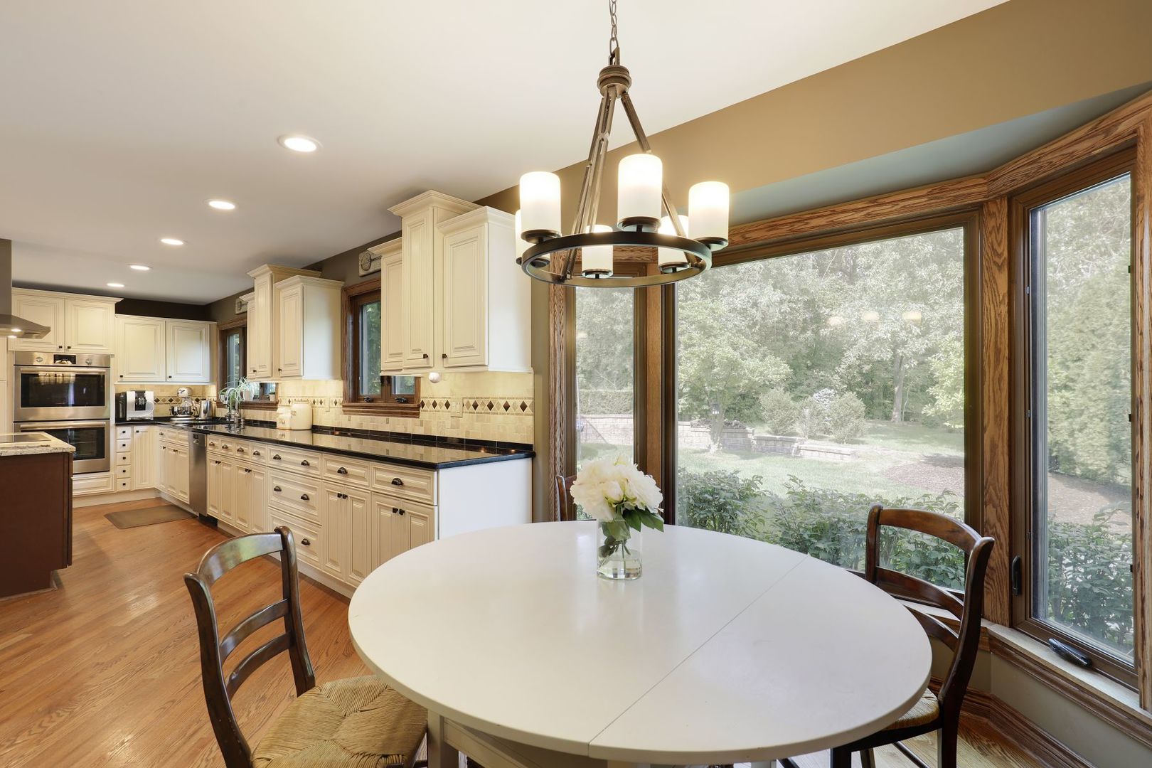11400 Burr Oak Lane Burr Ridge, IL 60527 - Photo 8 of 40 a kitchen with a table chairs and wooden floor