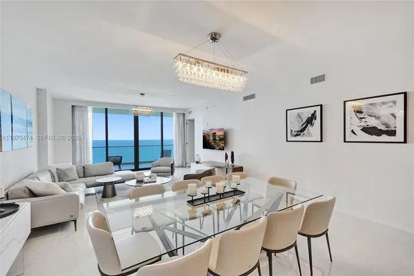 a living room with furniture and floor to ceiling windows
