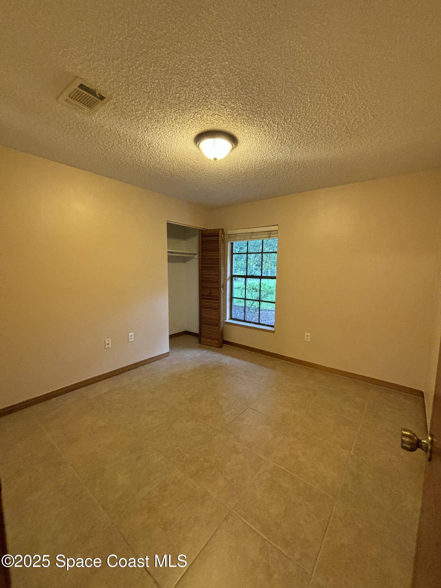 1201 Northeast Tropicana Road Palm Bay, FL 32905 - Photo 15 of 23 an empty room with windows