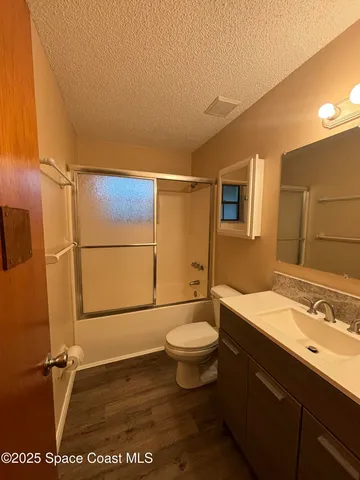 a bathroom with a sink a toilet a mirror and shower
