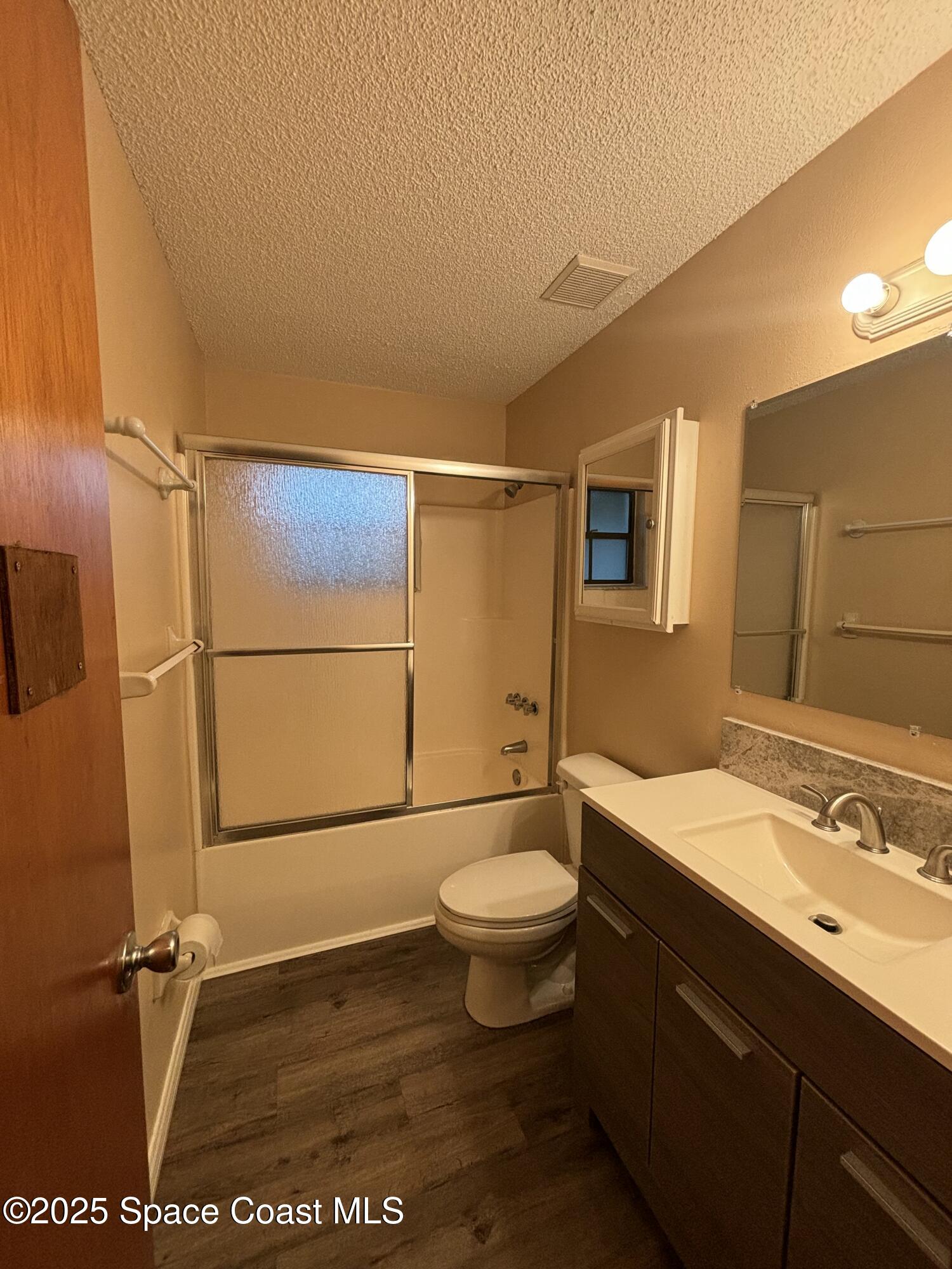 1201 Northeast Tropicana Road Palm Bay, FL 32905 - Photo 17 of 23 a bathroom with a sink a toilet a mirror and shower