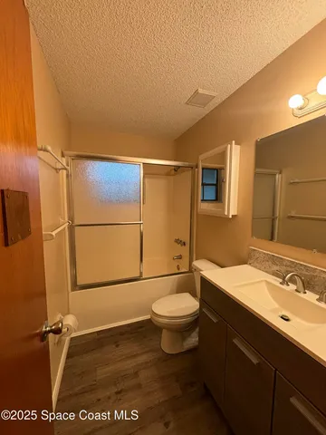 a bathroom with a sink a toilet a mirror and shower