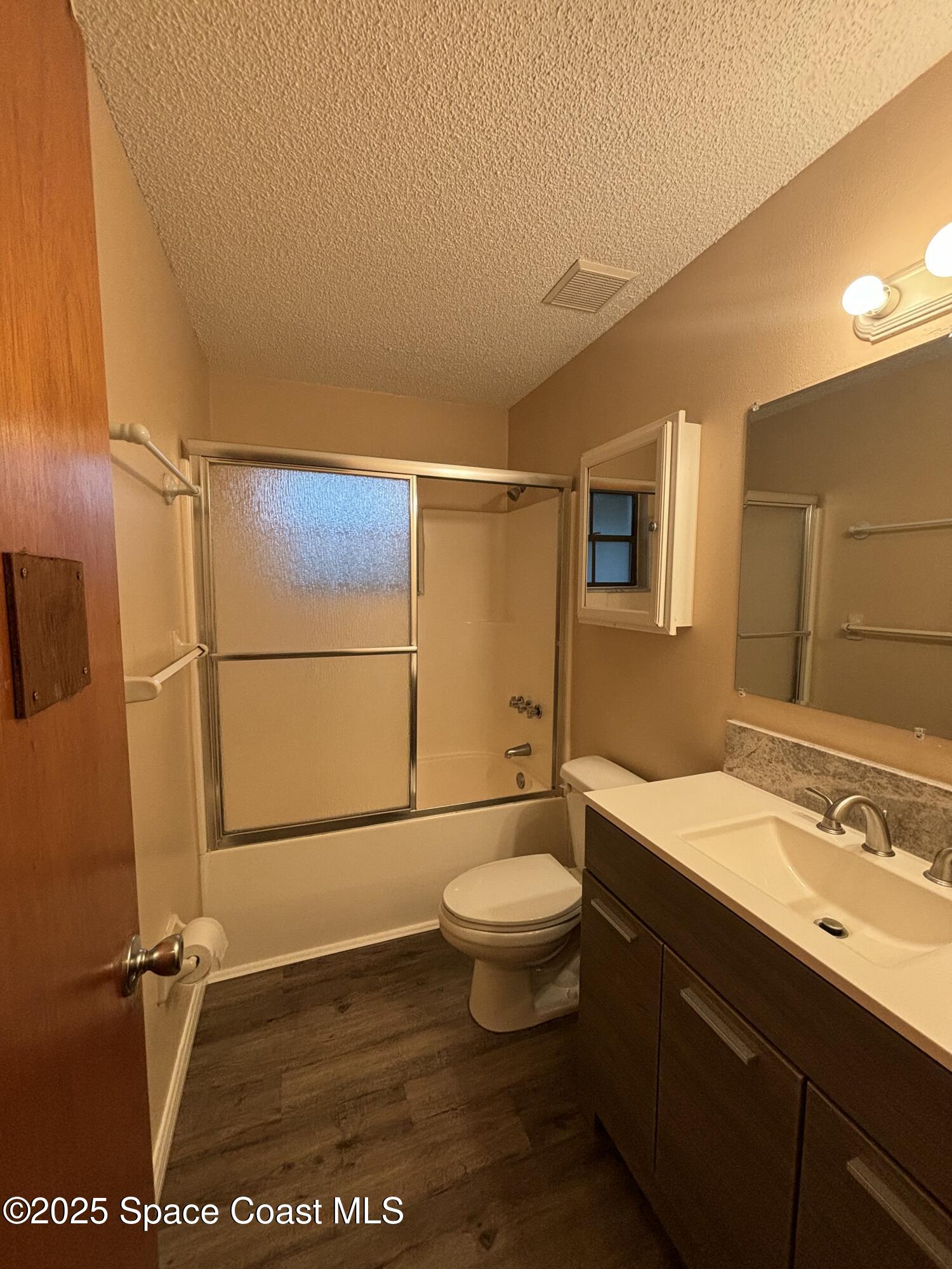 1201 Northeast Tropicana Road Palm Bay, FL 32905 - Photo 18 of 23 a bathroom with a sink a toilet a mirror and shower