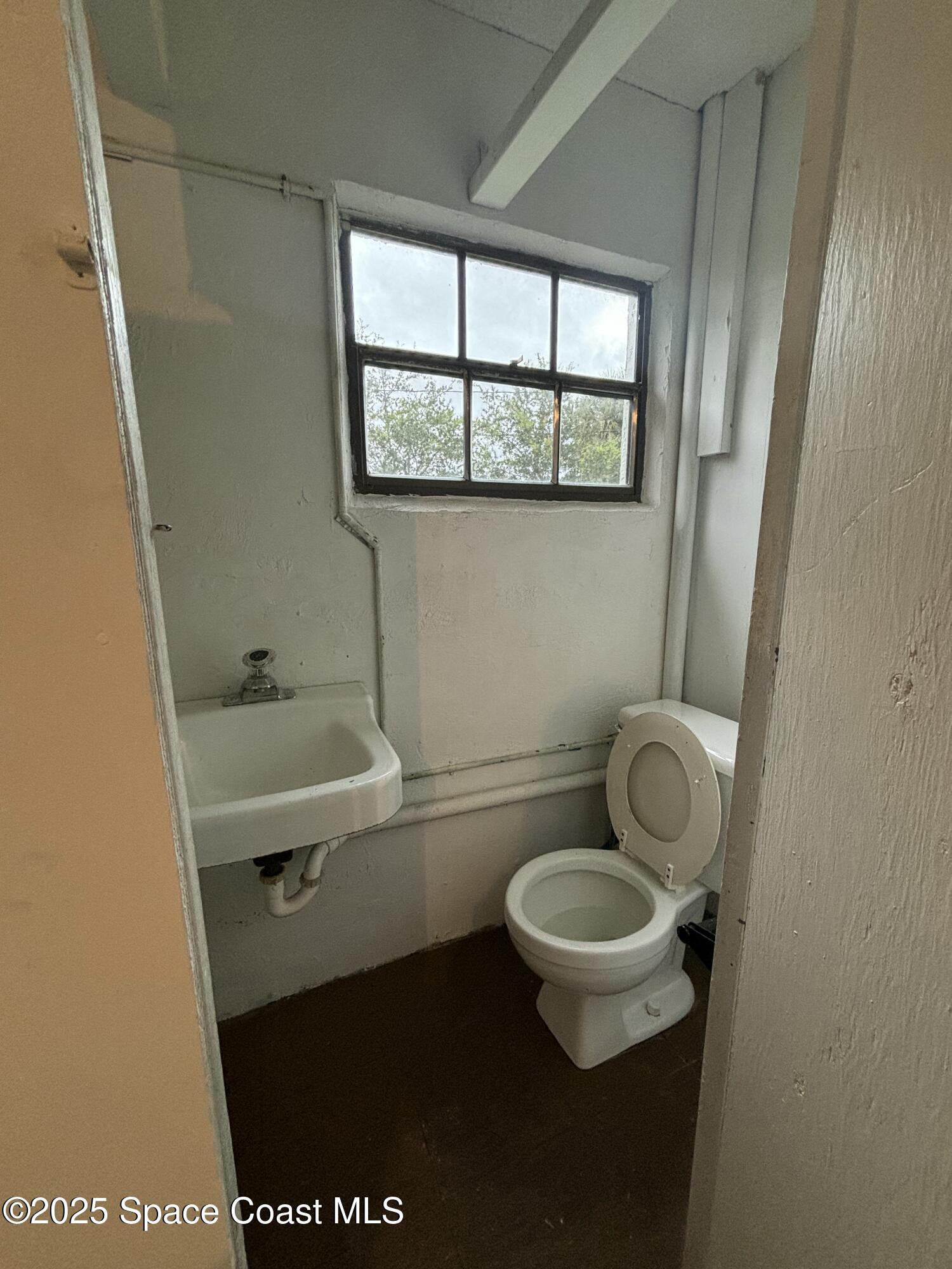 1201 Northeast Tropicana Road Palm Bay, FL 32905 - Photo 20 of 23 a bathroom with a toilet and a sink