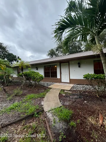 a front view of house with a garden