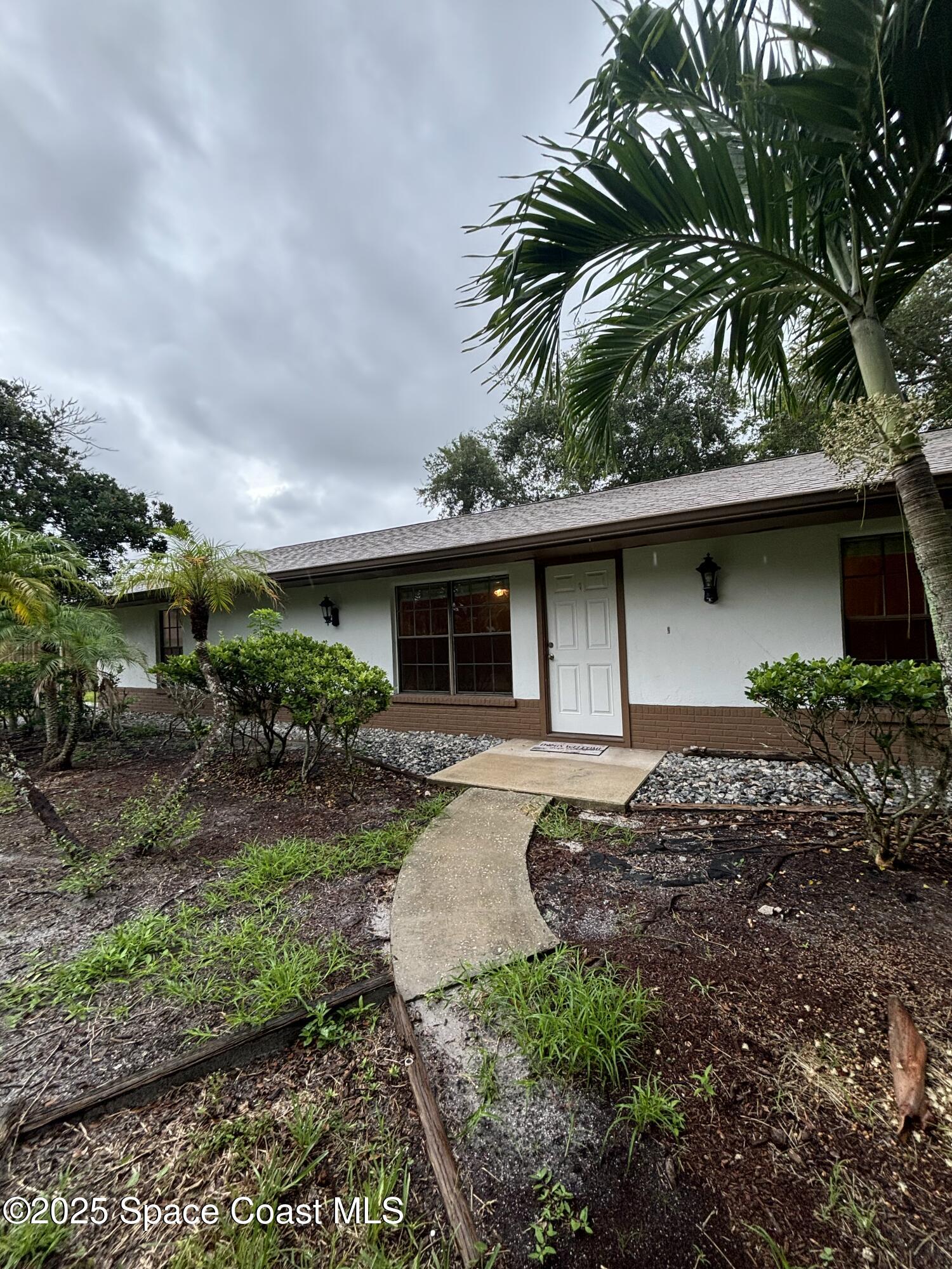 1201 Northeast Tropicana Road Palm Bay, FL 32905 - Photo 2 of 23 a front view of house with a garden
