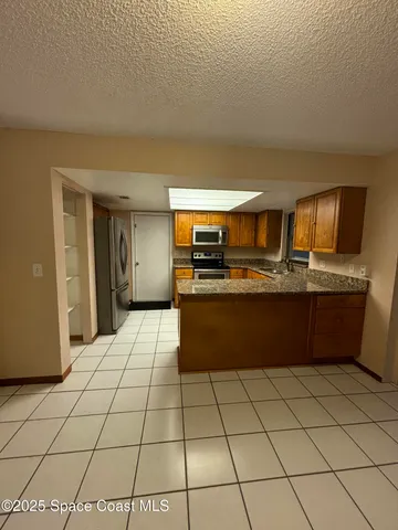 a kitchen with stainless steel appliances granite countertop a refrigerator and a stove