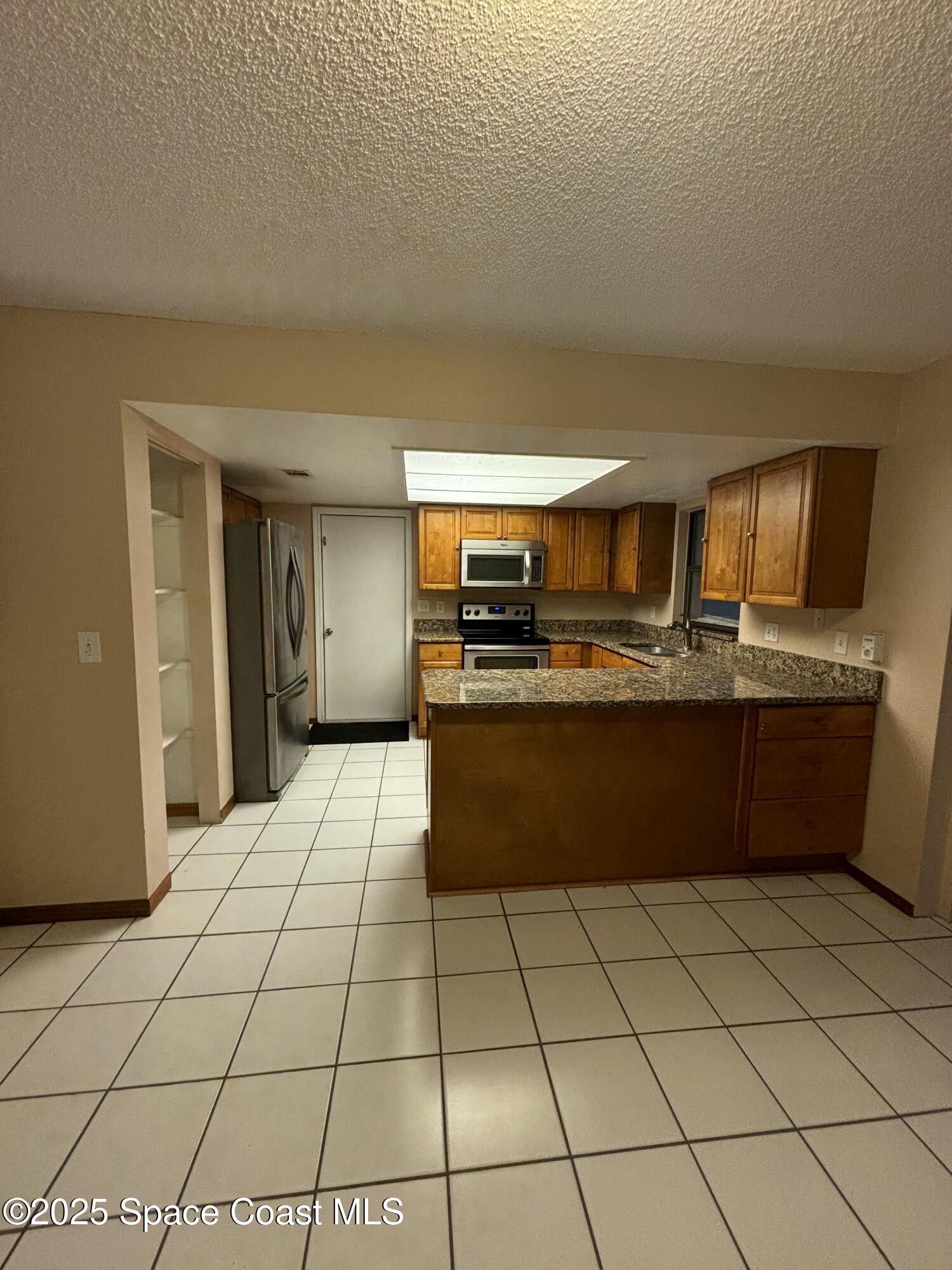 1201 Northeast Tropicana Road Palm Bay, FL 32905 - Photo 3 of 23 a kitchen with stainless steel appliances granite countertop a refrigerator and a stove
