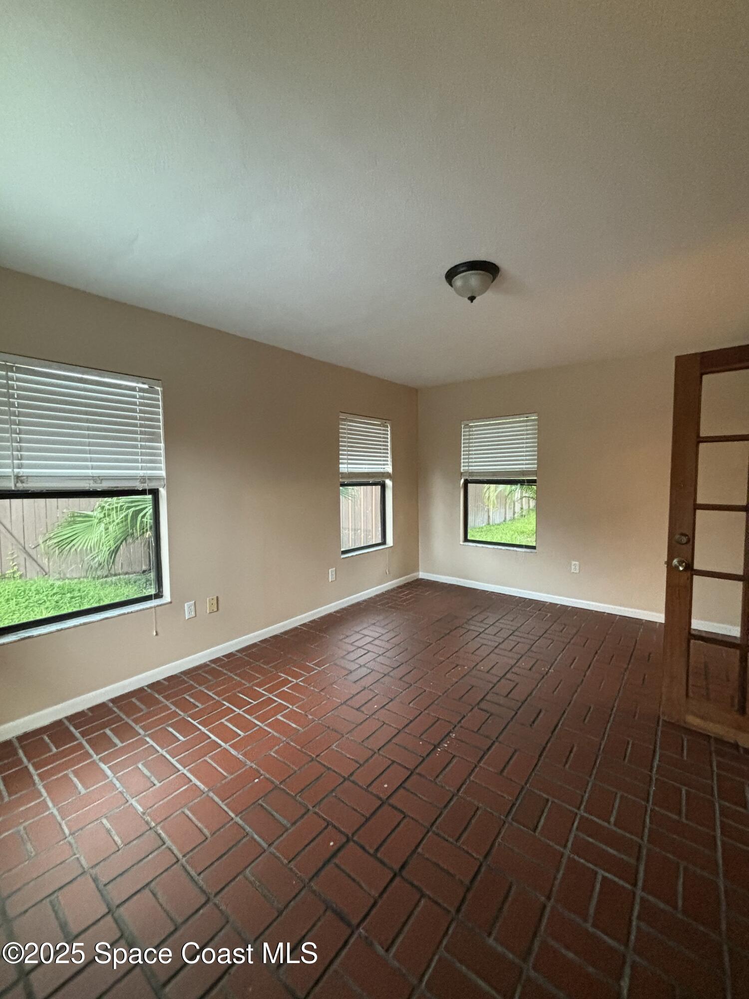 1201 Northeast Tropicana Road Palm Bay, FL 32905 - Photo 10 of 23 an empty room with windows and entrance