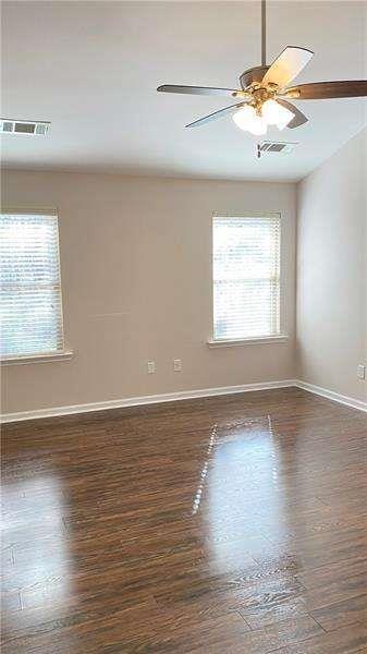 4408 Black Hills Drive Northwest Kennesaw, GA 30144 - Photo 18 of 33 an empty room with wooden floor chandelier fan and windows