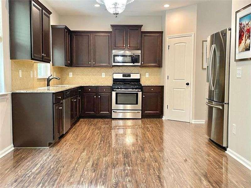 4408 Black Hills Drive Northwest Kennesaw, GA 30144 - Photo 2 of 33 a kitchen with stainless steel appliances granite countertop a refrigerator stove and sink