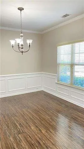 a view of a room with wooden floor chandelier and windows