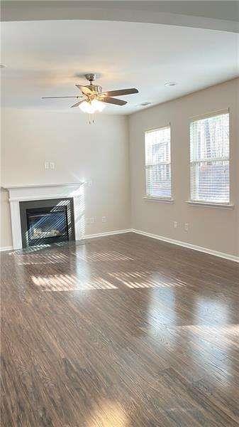 4408 Black Hills Drive Northwest Kennesaw, GA 30144 - Photo 8 of 33 an empty room with wooden floor a fireplace and windows