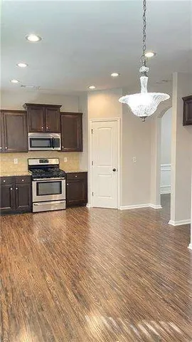 a kitchen with kitchen island stainless steel appliances a stove and a sink