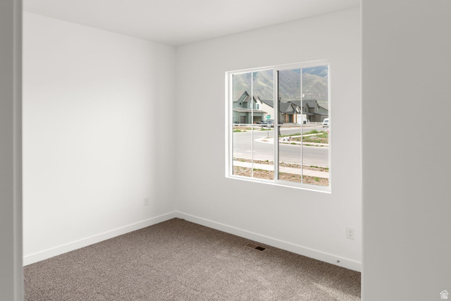 1417 West 2350th South, Unit 14 Perry, UT 84302 - Photo 12 of 19 Window-framed mountain scenery from a room featuring white walls, white trim, and textured carpeting