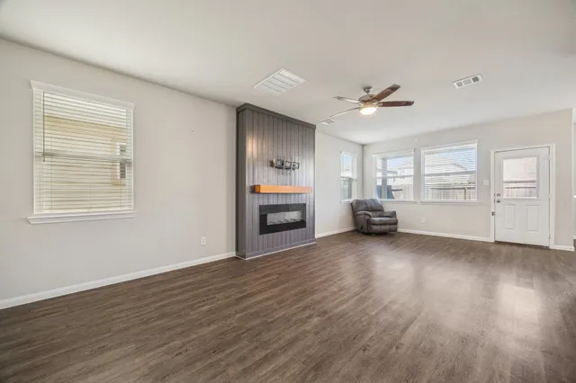 a view of a livingroom with furniture a ceiling fan and wooden floor