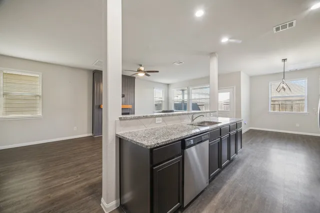 an empty room with kitchen appliances and wooden floor