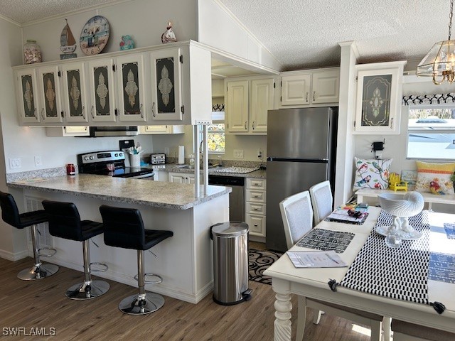 19681 Summerlin Road, Unit 404 Fort Myers, FL 33908 - Photo 10 of 34 a kitchen with stainless steel appliances kitchen island granite countertop a refrigerator a stove a sink and chairs
