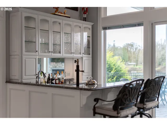 a kitchen with stainless steel appliances kitchen island granite countertop a stove and a view of living room