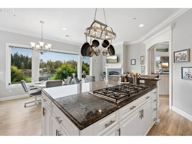 a kitchen with stainless steel appliances granite countertop a sink a stove and a wooden floors