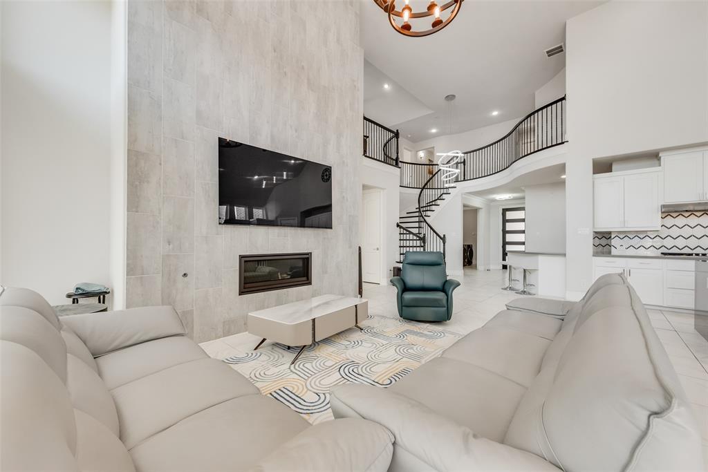 2341 Haft River Road Frisco, TX 75034 - Photo 4 of 36 Living room with a high ceiling, a high end fireplace, recessed lighting, and light tile patterned floors