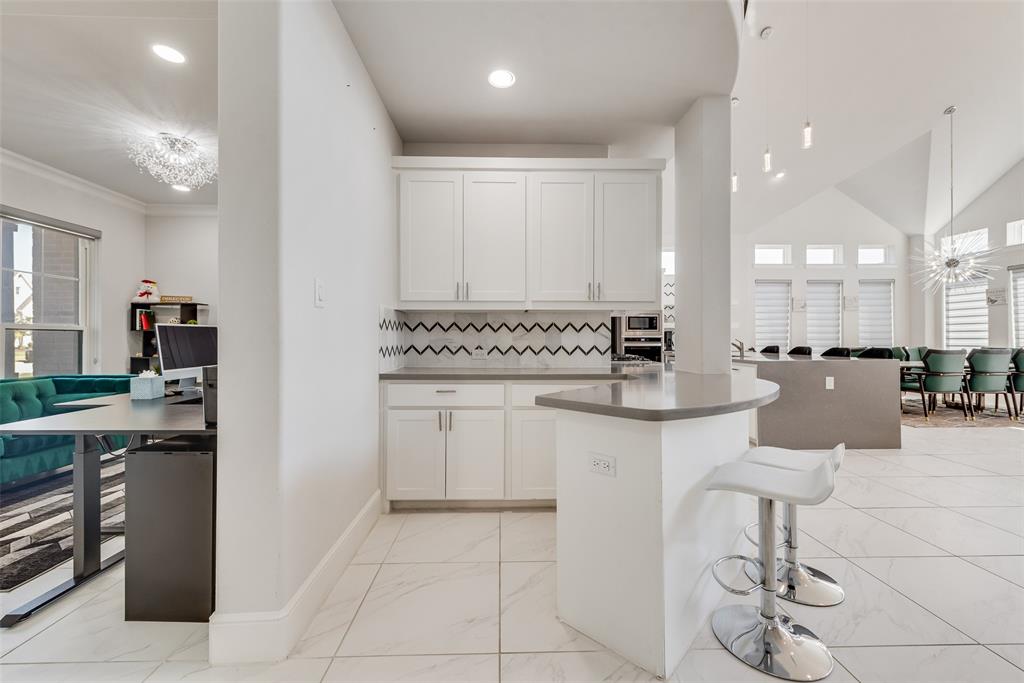 2341 Haft River Road Frisco, TX 75034 - Photo 36 of 36 Kitchen featuring a chandelier, white cabinetry, tasteful backsplash, a kitchen breakfast bar, and open floor plan