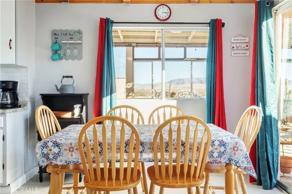 a kitchen with stainless steel appliances granite countertop a stove a sink a dining table and chairs