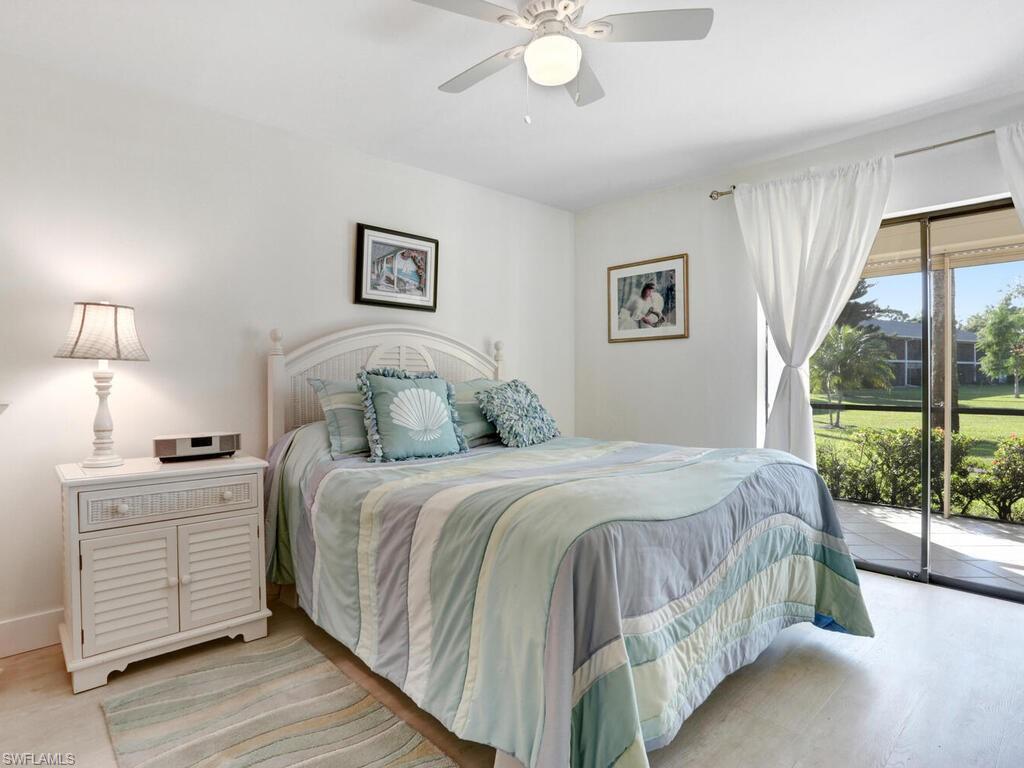 1232 Commonwealth Circle, Unit P102 Naples, FL 34116 - Photo 18 of 30 a bedroom with a large bed and a chandelier