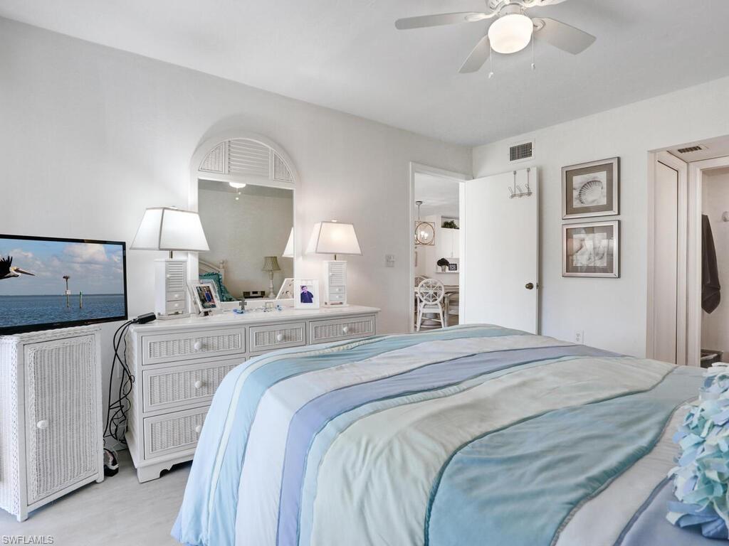 1232 Commonwealth Circle, Unit P102 Naples, FL 34116 - Photo 20 of 30 a bedroom with a bed and a mirror