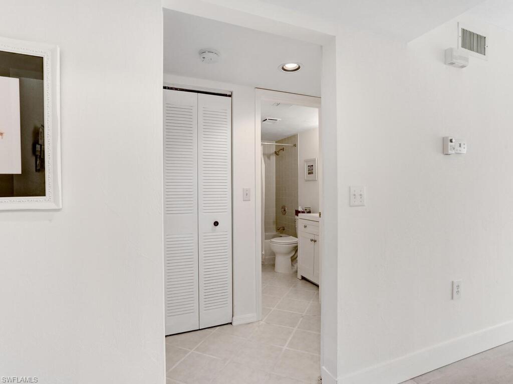 1232 Commonwealth Circle, Unit P102 Naples, FL 34116 - Photo 24 of 30 a bathroom with a granite countertop sink mirror and toilet
