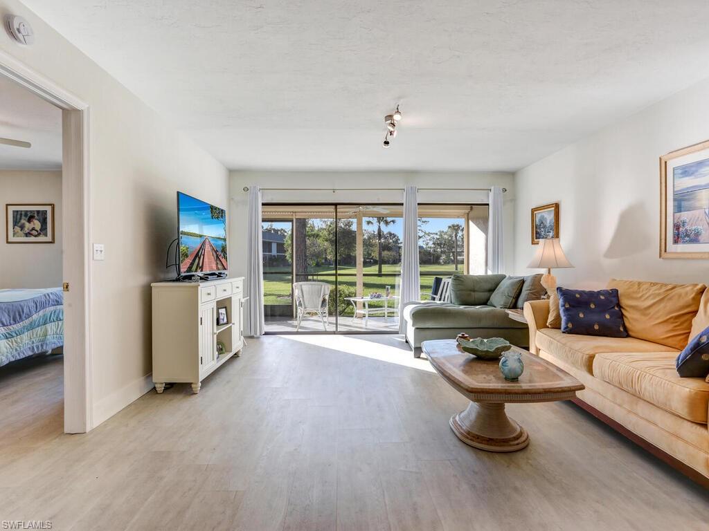 1232 Commonwealth Circle, Unit P102 Naples, FL 34116 - Photo 10 of 30 a living room with furniture and a flat screen tv