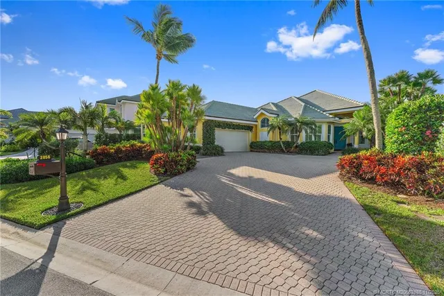 a front view of a house with a yard and potted plants