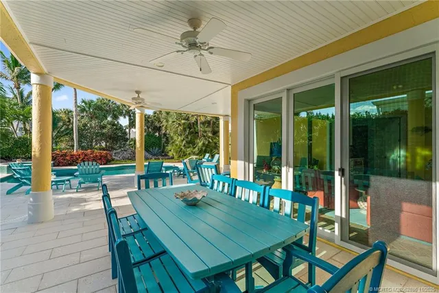 a view of a white house with a yard and potted plants