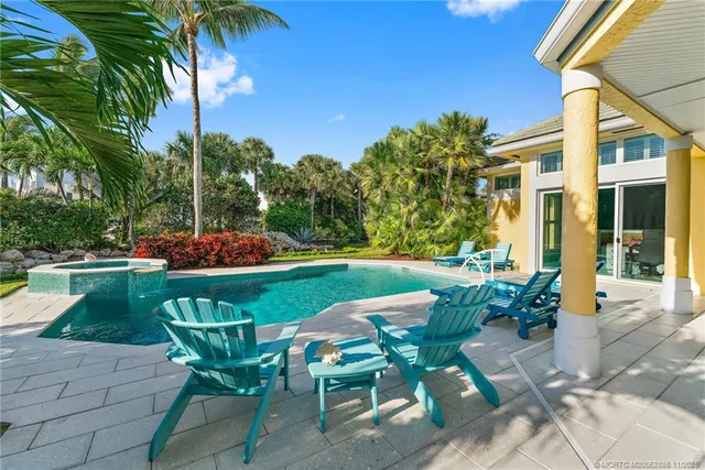 a view of a chairs and table in patio with a lake view