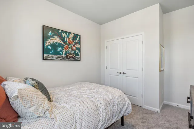 a bedroom with a bed and a painting on the wall