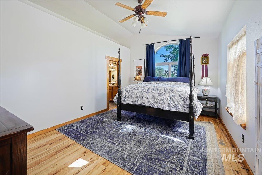 7639 Elko Lane Middleton, ID 83644 - Photo 20 of 47 Bedroom featuring light wood-style floors, ceiling fan, ensuite bathroom, and lofted ceiling