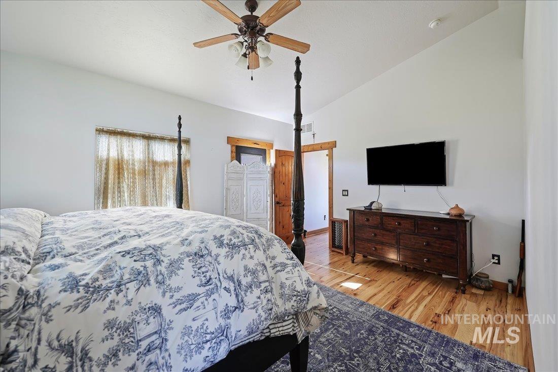 7639 Elko Lane Middleton, ID 83644 - Photo 21 of 47 Bedroom featuring wood finished floors, vaulted ceiling, and a ceiling fan