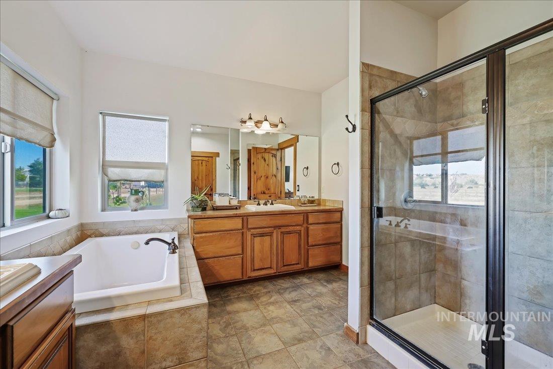 7639 Elko Lane Middleton, ID 83644 - Photo 24 of 47 Full bathroom featuring a bath, vanity, and a shower stall