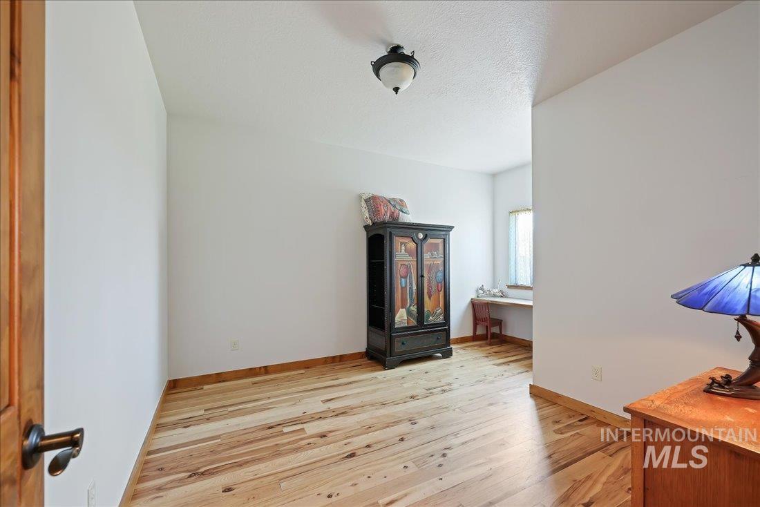 7639 Elko Lane Middleton, ID 83644 - Photo 27 of 47 Unfurnished room featuring light wood-style floors, an office area, and a textured ceiling
