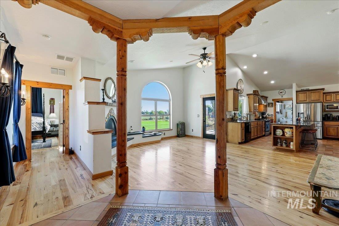 7639 Elko Lane Middleton, ID 83644 - Photo 6 of 47 Unfurnished living room featuring light tile patterned flooring, high vaulted ceiling, ceiling fan, and beam ceiling