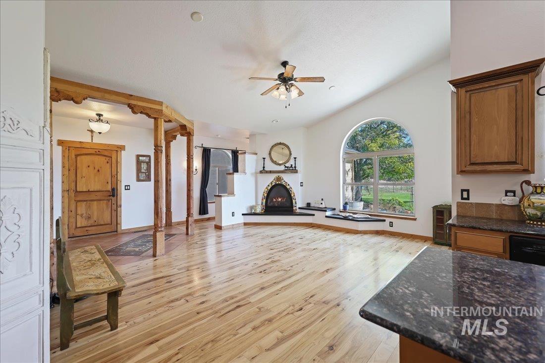 7639 Elko Lane Middleton, ID 83644 - Photo 8 of 47 Living room featuring light wood finished floors, a ceiling fan, and a warm lit fireplace