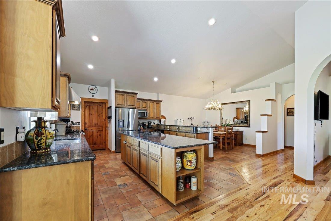 7639 Elko Lane Middleton, ID 83644 - Photo 10 of 47 Kitchen with open shelves, dark stone counters, pendant lighting, a chandelier, and recessed lighting