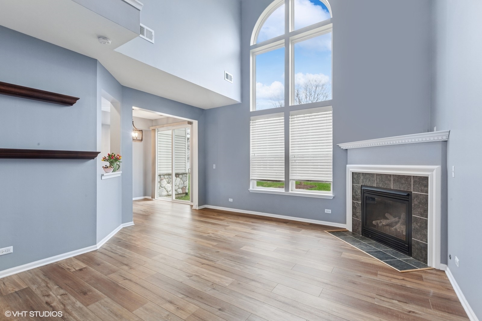 24843 Franklin Lane Plainfield, IL 60585 - Photo 2 of 18 a view of an empty room with wooden floor fireplace and a window