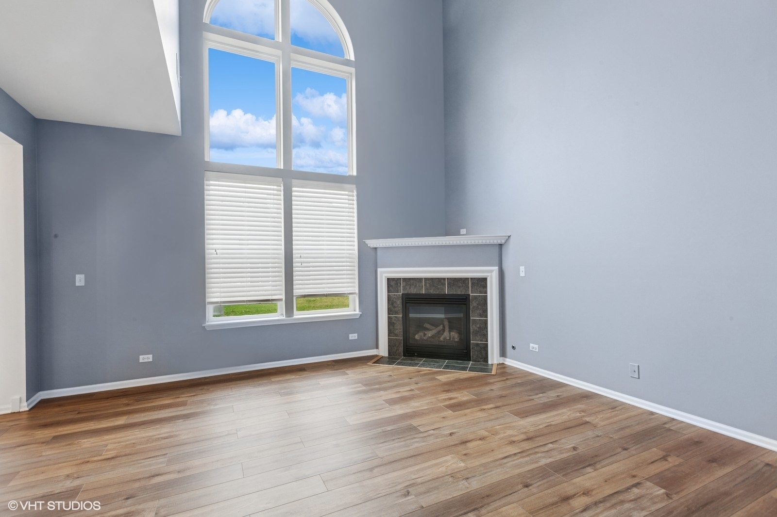 24843 Franklin Lane Plainfield, IL 60585 - Photo 7 of 18 an empty room with wooden floor and a fireplace